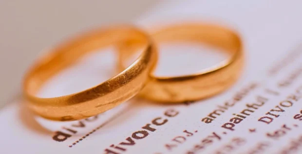 Two golden weddings rings on top of what it looks like a dictionary with the word divorce and its description. Modify an Illinois Divorce Decree After It's Finalized