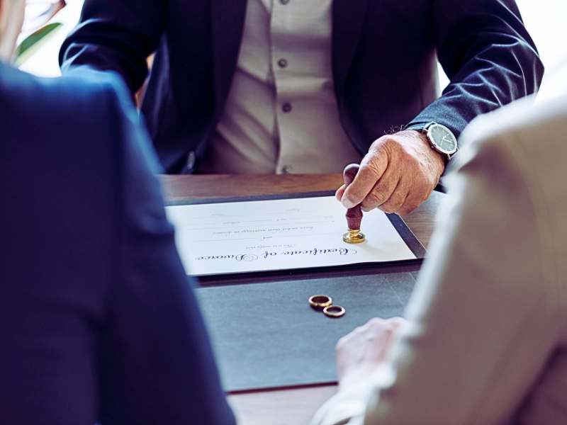 A formal setting where a man is stamping a document, likely a legal certificate.